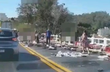 Carreta tomba e pessoas furtam carga de refrigerantes na 040
