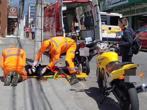 Mulher fica ferida em acidente entre motocicleta e van escolar