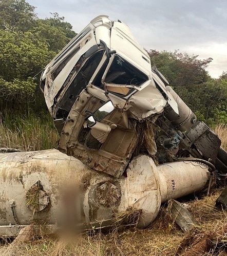 Carreta capota, sai da pista e motorista fica preso nas ferragens
