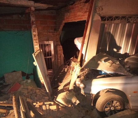 Jovem inabilitado pega carro emprestado, bate e destrói parcialmente residência