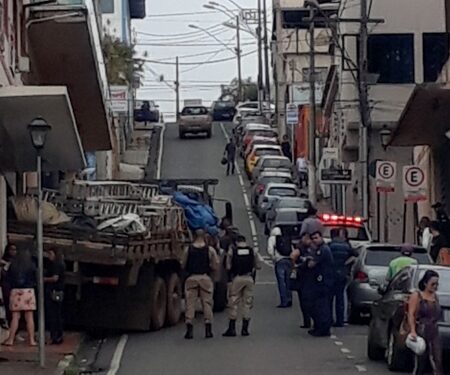 Caminhão desce rua íngreme e bate em parede de loja